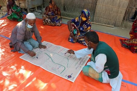 Two men sitting on floor analysing a map