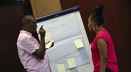 Man and lady in front of a whiteboard titled 'Highways'